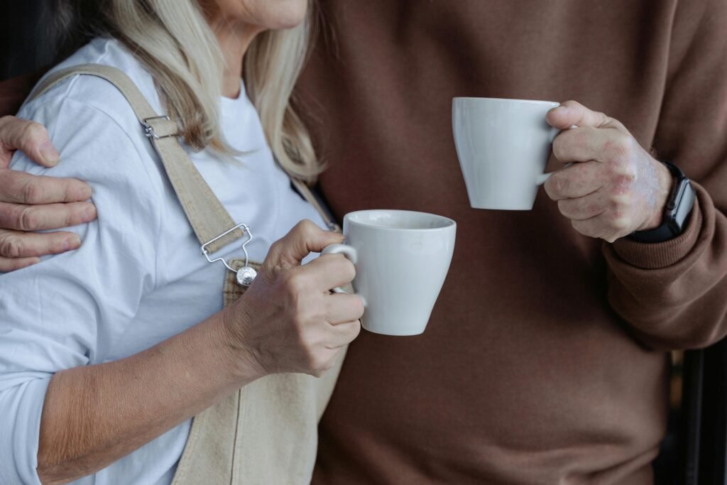 pexels-photo-7329529-7329529 An elderly couple enjoying warm drinks in a cozy home setting.